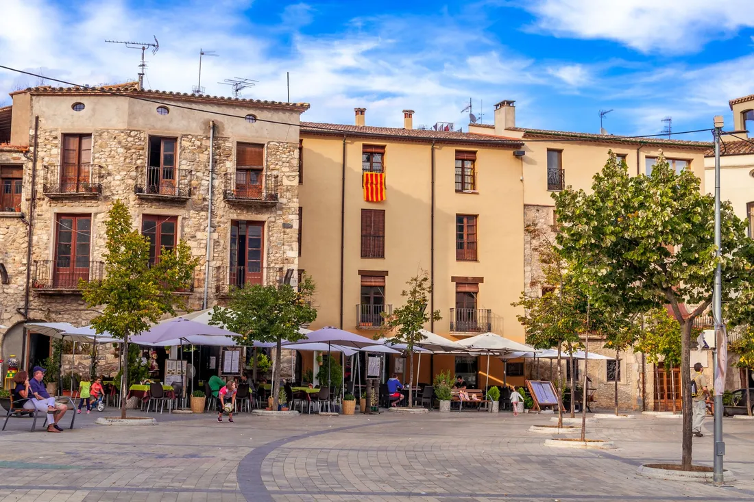 Belebter Stadtplatz mit Cafés und Menschen in einem Neuköllner Kiez